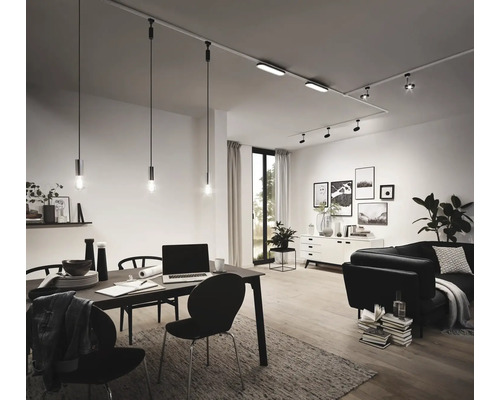 Salon avec table à manger, canapé et système de rails avec spots et suspensions.