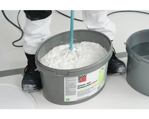 Eimer mit Baumit Airless und Rollspachtel Silikat wird mit einem Rührgerät gemischt