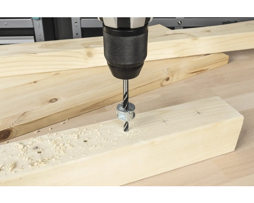 Foret à bois perçant un trou dans une planche de bois