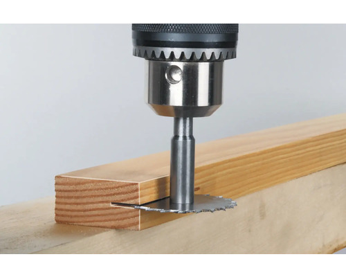 Fraise à rainurer fixée sur une perceuse en train de travailler une pièce de bois