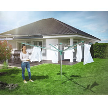 Drehflügelwäscheständer im Garten mit aufgehängter Wäsche und Frau