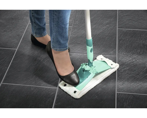 Femme utilisant une serpillière sur un sol carrelé