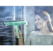 Femme nettoie les fenêtres avec un essuie-glace pour fenêtre