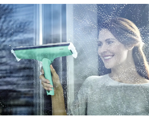 Femme nettoie les fenêtres avec un essuie-glace pour fenêtre