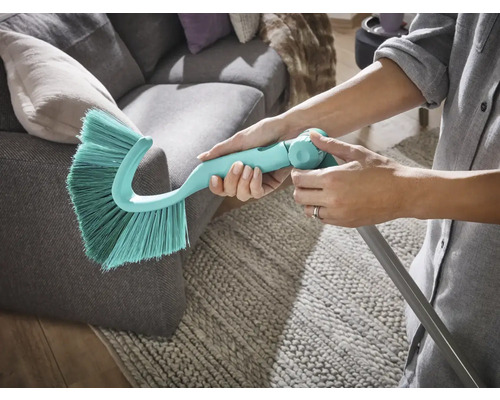 Plumeau avec manche télescopique utilisé sur un canapé