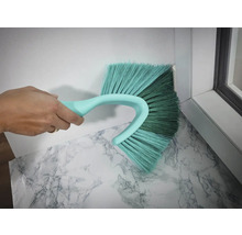 Brosse à poussière d''angle en cours d''utilisation pour nettoyer un coin