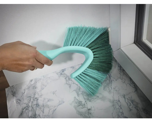 Brosse à poussière d''angle en cours d''utilisation pour nettoyer un coin