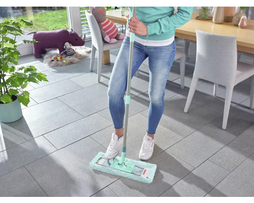 Femme nettoie un sol carrelé avec une serpillère