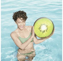 Femme tenant un ballon gonflable kiwi dans la piscine