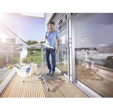 Un homme utilise un séchoir à linge sur le balcon.
