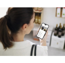 Frau betrachtet Überwachungskamera-Aufnahmen auf einem Smartphone