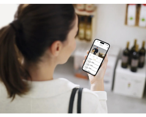 Frau betrachtet Überwachungskamera-Aufnahmen auf einem Smartphone