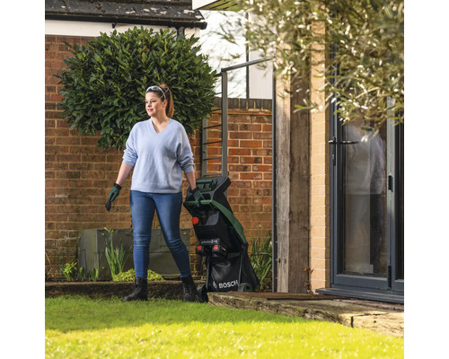 Femme dans le jardin avec un broyeur de végétaux Bosch