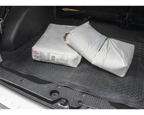 Zwei Säcke Zement im Kofferraum eines Autos.