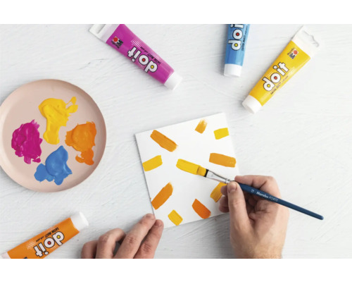 Scène avec des tubes de peinture, un pinceau et une toile peinte pour le bricolage