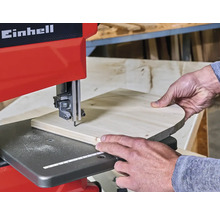 Einhell Logo. Bandsäge im Einsatz mit Werkstück.