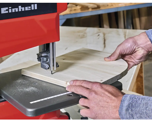 Einhell Logo. Bandsäge im Einsatz mit Werkstück.
