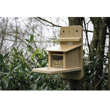 Nichoir en bois avec de la nourriture fixée à un arbre