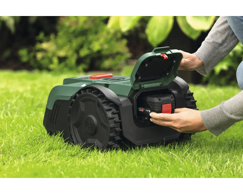 Tondeuse autoportée avec batterie insérée dans l'herbe