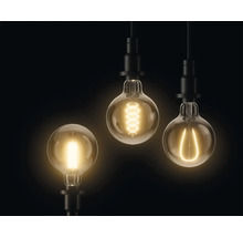 Trois ampoules avec différents filaments lumineux suspendues au plafond