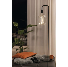 Stehleuchte mit Glühbirne, Kissen, Kopfhörern und Pflanze auf Hocker