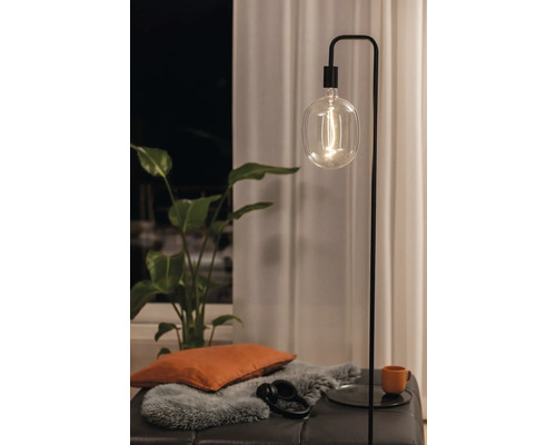 Stehleuchte mit Glühbirne, Kissen, Kopfhörern und Pflanze auf Hocker