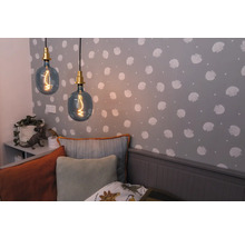 Zwei Pendelleuchten mit dekorativen Glühbirnen in einem Kinderzimmer mit Muscheltapete