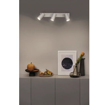 Plafonnier avec trois spots au-dessus d'un buffet avec décoration