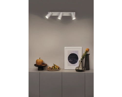 Plafonnier avec trois spots au-dessus d'un buffet avec décoration