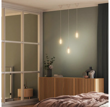 Schlafzimmer mit Bett, Kommode, Glaswand und Pendelleuchten