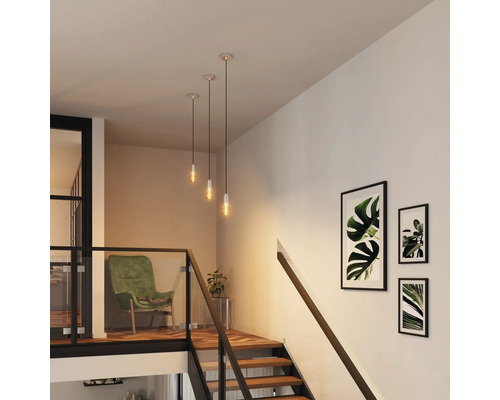 Treppenhaus mit Pendelleuchten und Wandbildern