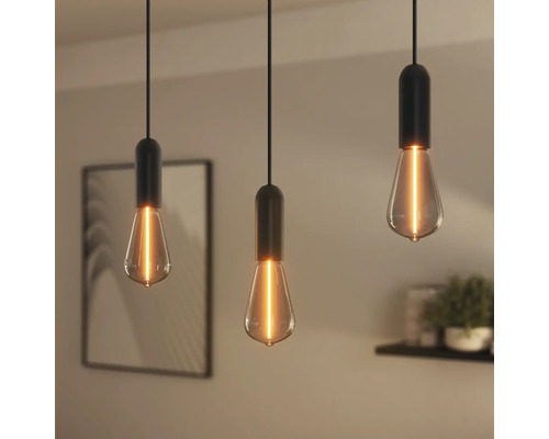 Trois suspensions avec douilles noires et ampoules Edison dans un intérieur.