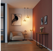 Salon avec fauteuil, table, lampadaire, suspensions et décorations