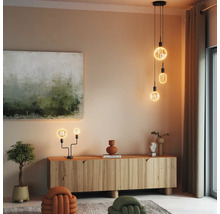 Wohnzimmer mit Holzkommode, Gemälde und dekorativer Beleuchtung durch Hänge- und Tischlampen.