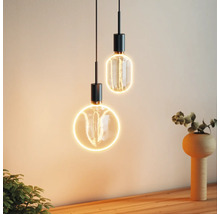Zwei dekorative Pendelleuchten mit runden und ovalen Formen beleuchten einen Innenraum.