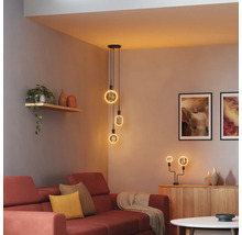 Wohnzimmer mit rotem Sofa, Kommode und Pendelleuchte mit mehreren LED-Leuchtmitteln