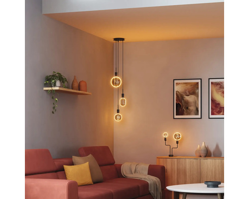 Wohnzimmer mit rotem Sofa, Kommode und Pendelleuchte mit mehreren LED-Leuchtmitteln