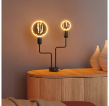 Dekorative Tischleuchte mit zwei Glühbirnen auf einem Holzschrank