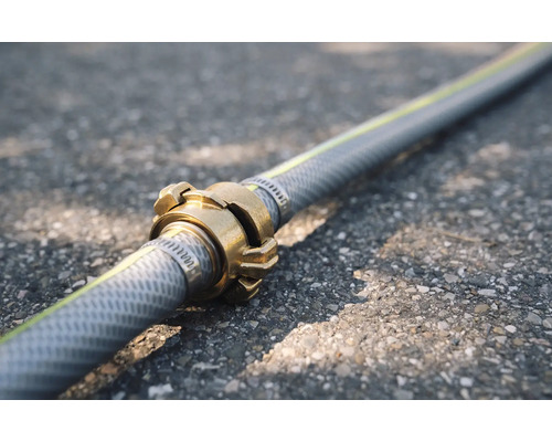 Gartenschlauch mit Messingkupplung auf Asphalt