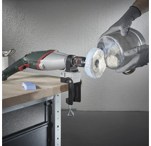 Perceuse avec accessoire de polissage et pièce sur un établi