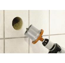 Perceuse à carrelage perçant un trou dans un mur carrelé