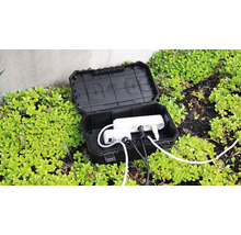 Boîtier de distribution électrique noir ouvert pour l'extérieur avec multiprise et câbles.