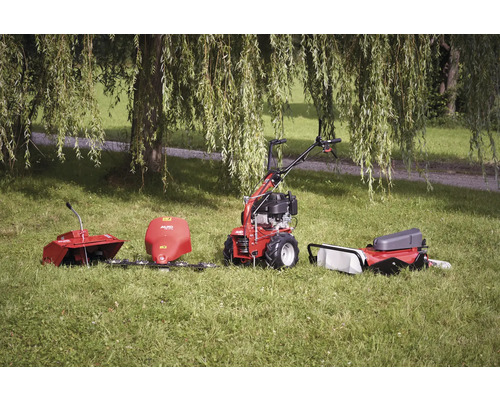 Motoculteur avec divers accessoires dans l'herbe
