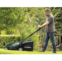 Ein Mann benutzt einen Rasenmäher der Marke Bosch in einem Garten.