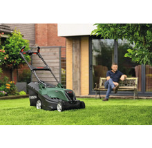 Bosch Rasenmäher auf Rasenfläche mit sitzendem Mann im Hintergrund