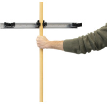 Un homme fixe un manche dans un support mural pour outils