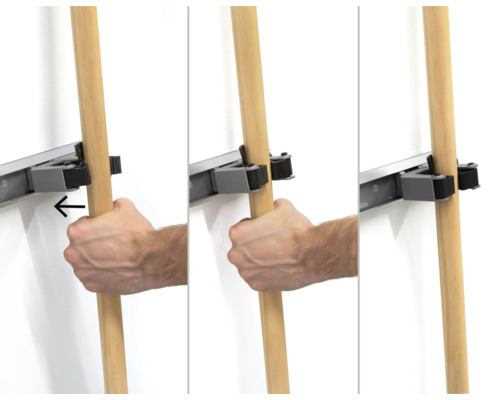 Présentation d'un système de support d'outils en cours d'utilisation avec une main accrochant un manche en bois