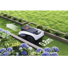 Robot tondeuse dans le jardin entre parterres et pelouses