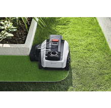 Robot tondeuse entretenant une pelouse dans un jardin.