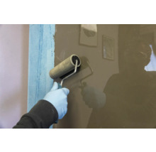 Application d'un revêtement à l'aide d'un rouleau à peinture sur un mur